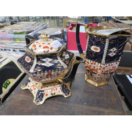 144 - A VICTORIAN STYLE TEAPOT AND STAND TOGETHER WITH A WATER JUG IN IMARI COLOURS A/F