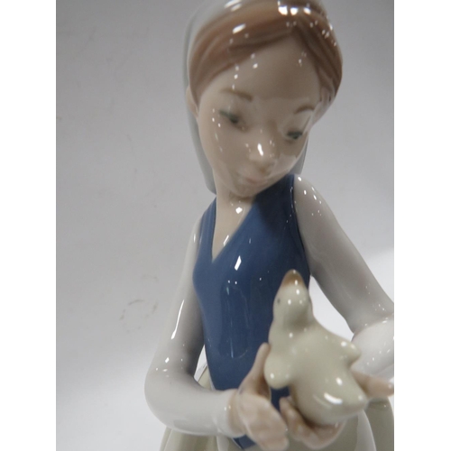 329 - A NAO FIGURE OF A GIRL HOLDING A BIRD TOGETHER WITH A SMALL NAO FIGURE OF A BOY HOLDING A FOOTBALL