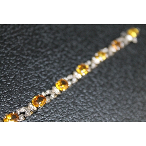 89 - AN UNMARKED WHITE METAL GEM SET BRACELET, set with eleven citrine style stones and diamonds on a box... 