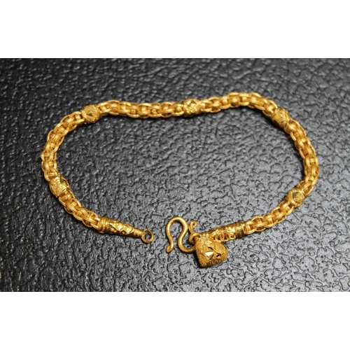 115 - AN ORNATE YELLOW METAL BRACELET WITH HEART CHARM, stamped 96.5%, with simple S link fastening, appro... 