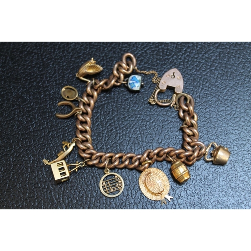 128 - A 9CT ROSE GOLD CHARM BRACELET ADORNED WITH TEN ASSORTED CHARMS, approx weight 31.9g