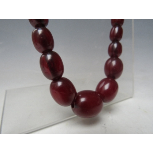 58 - A CHERRY RED FATURAN AMBER GRADUATED OVAL BEAD NECKLACE, approx L 68 cm, approx weight 63 g