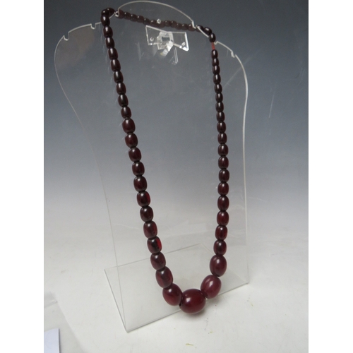 58 - A CHERRY RED FATURAN AMBER GRADUATED OVAL BEAD NECKLACE, approx L 68 cm, approx weight 63 g