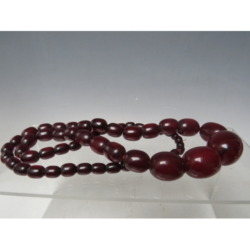 58 - A CHERRY RED FATURAN AMBER GRADUATED OVAL BEAD NECKLACE, approx L 68 cm, approx weight 63 g