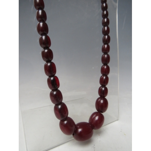 58 - A CHERRY RED FATURAN AMBER GRADUATED OVAL BEAD NECKLACE, approx L 68 cm, approx weight 63 g