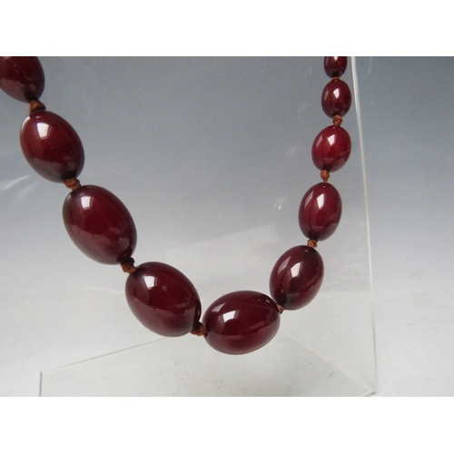 59 - A CHERRY RED FATURAN AMBER GRADUATED OVAL BEAD NECKLACE, approx L 70 cm, approx weight 51 g