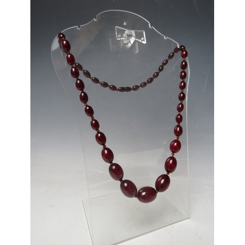 59 - A CHERRY RED FATURAN AMBER GRADUATED OVAL BEAD NECKLACE, approx L 70 cm, approx weight 51 g