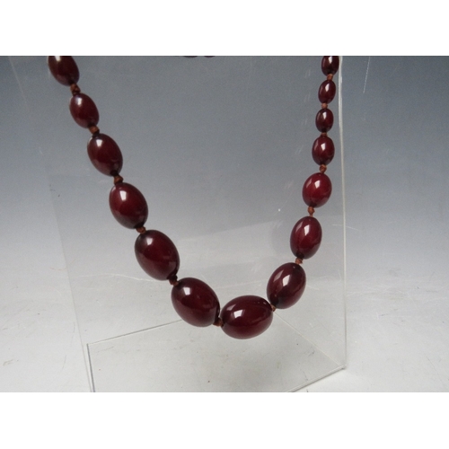 59 - A CHERRY RED FATURAN AMBER GRADUATED OVAL BEAD NECKLACE, approx L 70 cm, approx weight 51 g