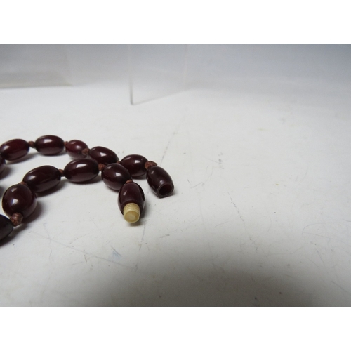 59 - A CHERRY RED FATURAN AMBER GRADUATED OVAL BEAD NECKLACE, approx L 70 cm, approx weight 51 g