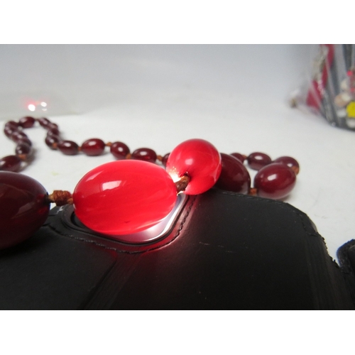 59 - A CHERRY RED FATURAN AMBER GRADUATED OVAL BEAD NECKLACE, approx L 70 cm, approx weight 51 g