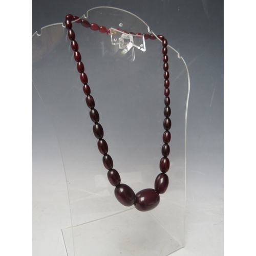 60 - A CHERRY RED FATURAN AMBER GRADUATED OVAL BEAD NECKLACE, approx L 54 cm, approx weight 39 g