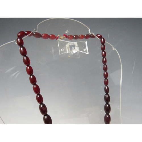 60 - A CHERRY RED FATURAN AMBER GRADUATED OVAL BEAD NECKLACE, approx L 54 cm, approx weight 39 g