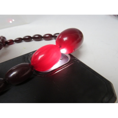 60 - A CHERRY RED FATURAN AMBER GRADUATED OVAL BEAD NECKLACE, approx L 54 cm, approx weight 39 g