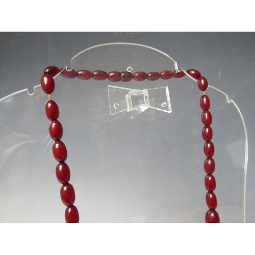 61 - A CHERRY RED FATURAN AMBER GRADUATED OVAL BEAD NECKLACE, approx L 59 cm, approx weight 40 g