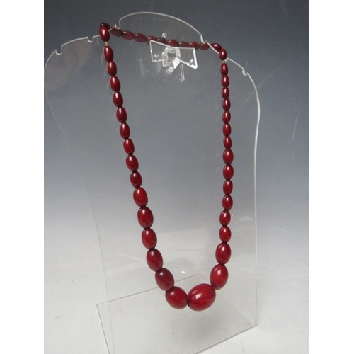 61 - A CHERRY RED FATURAN AMBER GRADUATED OVAL BEAD NECKLACE, approx L 59 cm, approx weight 40 g