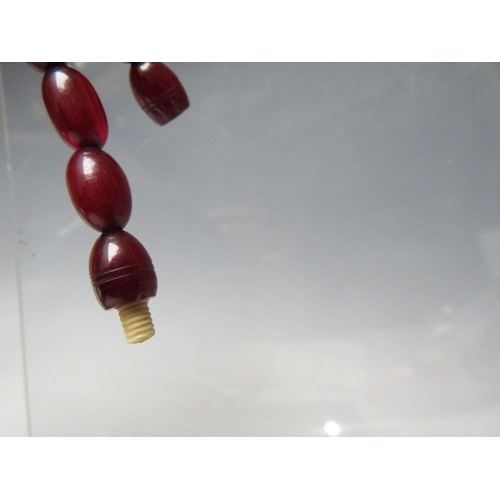 61 - A CHERRY RED FATURAN AMBER GRADUATED OVAL BEAD NECKLACE, approx L 59 cm, approx weight 40 g