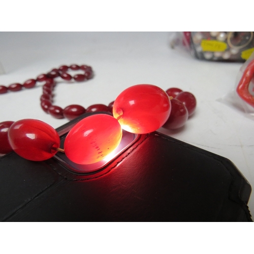 61 - A CHERRY RED FATURAN AMBER GRADUATED OVAL BEAD NECKLACE, approx L 59 cm, approx weight 40 g