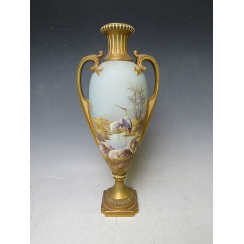 191 - A ROYAL WORCESTER TWIN HANDLED PEDESTAL VASE BY W. POWELL, decorated with storks in a landscape, sig... 