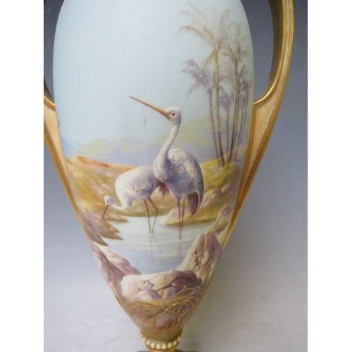 191 - A ROYAL WORCESTER TWIN HANDLED PEDESTAL VASE BY W. POWELL, decorated with storks in a landscape, sig... 