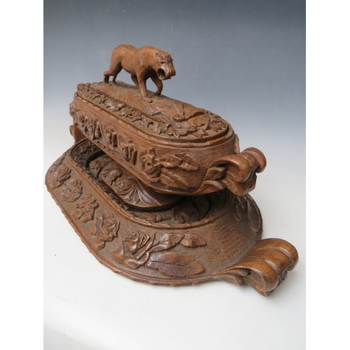 207 - A LARGE BLACK FOREST CARVED LIDDED DISH ON A CARVED BASE, the handle in the shape if a wild animal, ... 