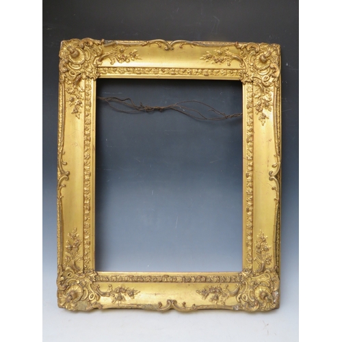 28 - A 19TH CENTURY DECORATIVE GOLD SWEPT FRAME, frame W 10 cm, rebate 53 x 45 cm