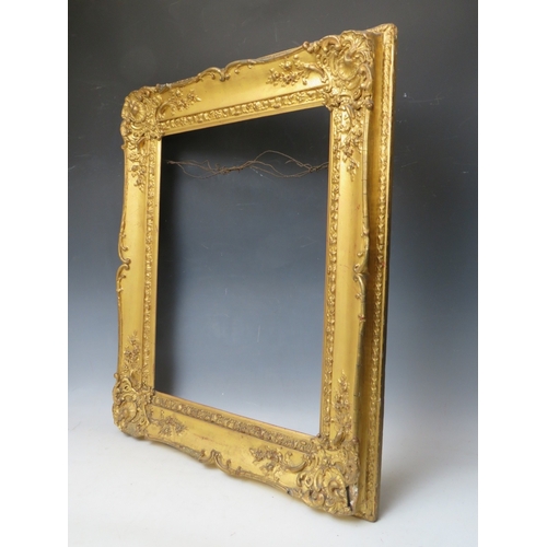 28 - A 19TH CENTURY DECORATIVE GOLD SWEPT FRAME, frame W 10 cm, rebate 53 x 45 cm