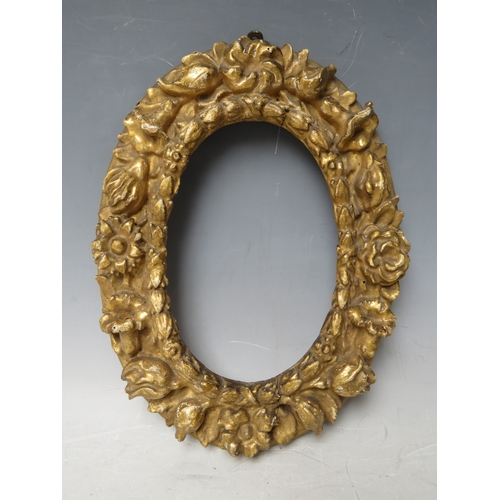 32 - A 19TH CENTURY SMALL OVAL CARVED WOODEN DECORATIVE GOLD FRAME, frame W 4.5 cm, rebate 17 x 12 cm