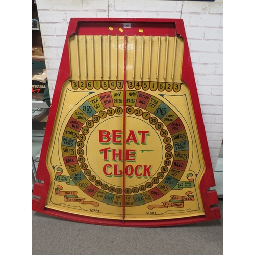 568 - 'BEAT THE CLOCK' A MID 20TH CENTURY PAINTED WOOD FAIRGROUND ROLL A BALL GAME BOARD, in red and yello... 