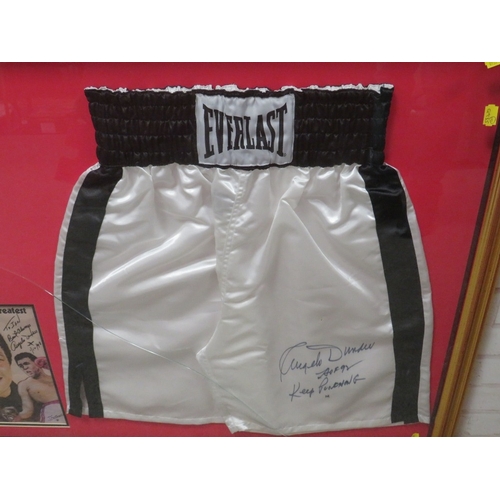 317 - A PAIR OF FRAMED BOXING SHORTS AND A PICUTRE OF MUHAMMAD ALI, both signed by trainer Angelo Dundee, ... 