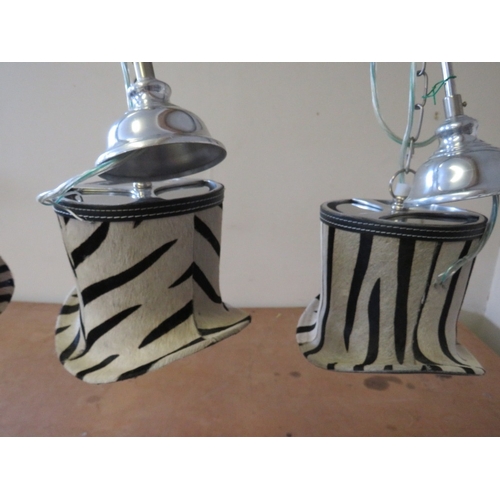 508 - A SET OF FOUR UNUSUAL DESIGNER ZEBRA PATTERN TOP HAT PENDANT LIGHTS, in chrome and faux zebra fur