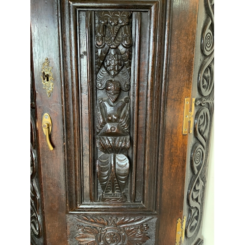 704 - An antique oak heavily carved corner cupboard on a later stand, cupboard H 113 cm