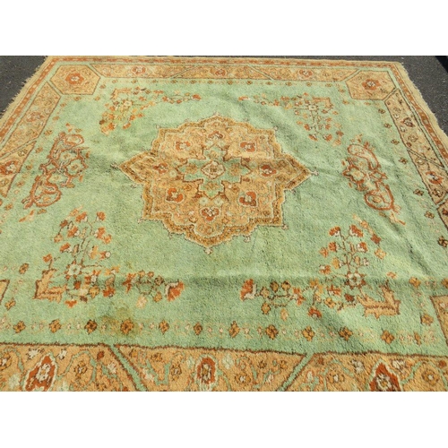 720 - A large late 19th/early 20th century woollen rug on a mainly green ground, approximately 295 x 272 c... 