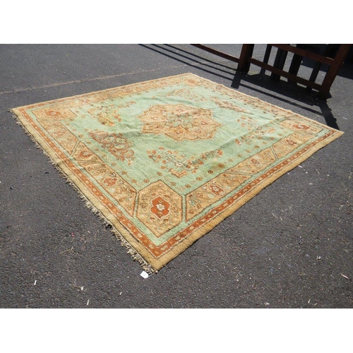 720 - A large late 19th/early 20th century woollen rug on a mainly green ground, approximately 295 x 272 c... 