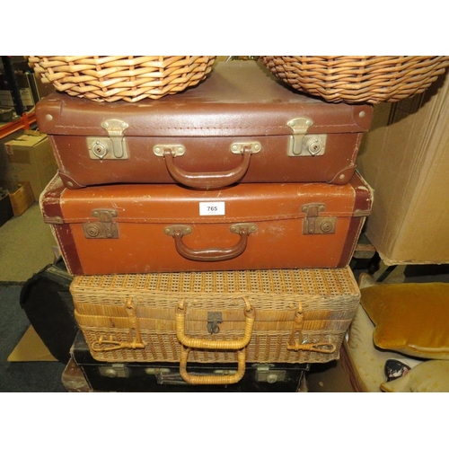 765 - A large collection of vintage suitcases, wicker hampers and baskets