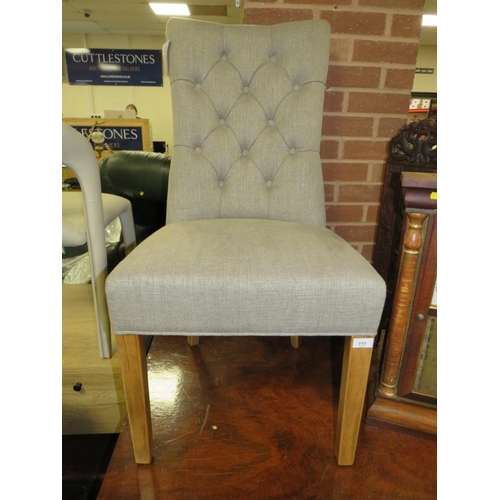 777 - A modern grey upholstered button backed dining chair