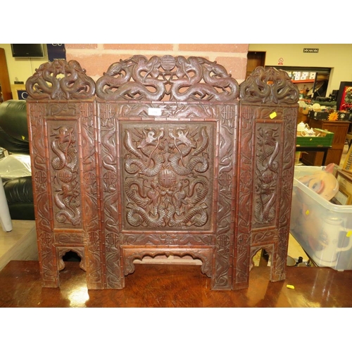 779 - A carved Eastern hardwood fire screen with dragon detail