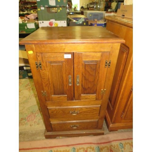 792 - A small oak two door cabinet with two drawers below