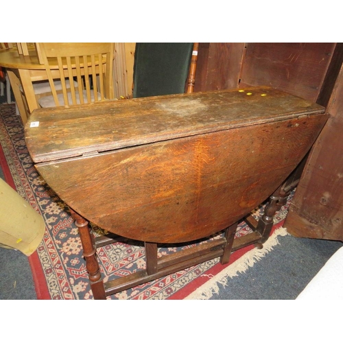 803 - An antique oak drop leaf dining table with gate leg mechanism