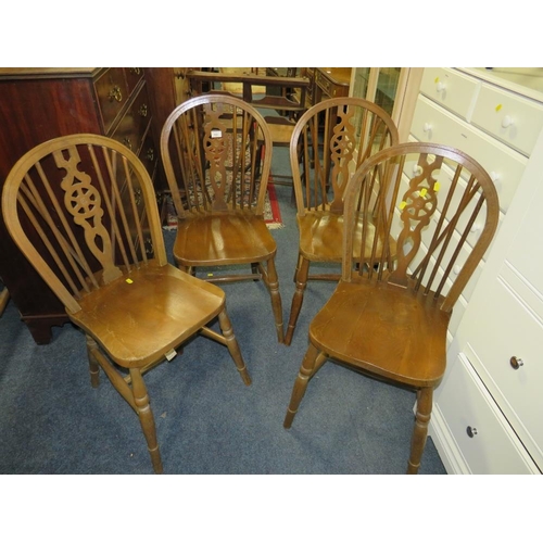 832 - A set of four wheel back dining chairs