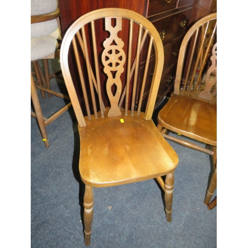 832 - A set of four wheel back dining chairs