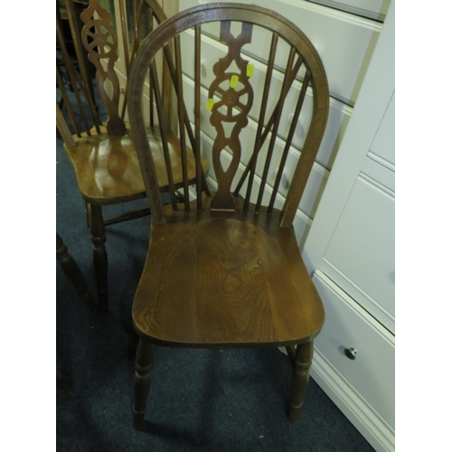 832 - A set of four wheel back dining chairs