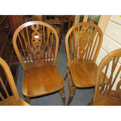 832 - A set of four wheel back dining chairs