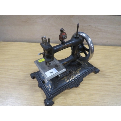 286 - A VINTAGE MINATURE SEWING MACHINE WITH SPARES