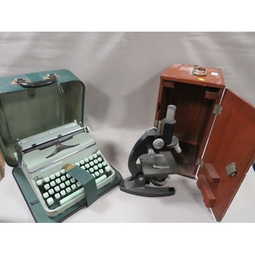 495 - A VINTAGE WOODEN CASED MICROSCOPE WITH A PORTABLE TYPEWRITTER