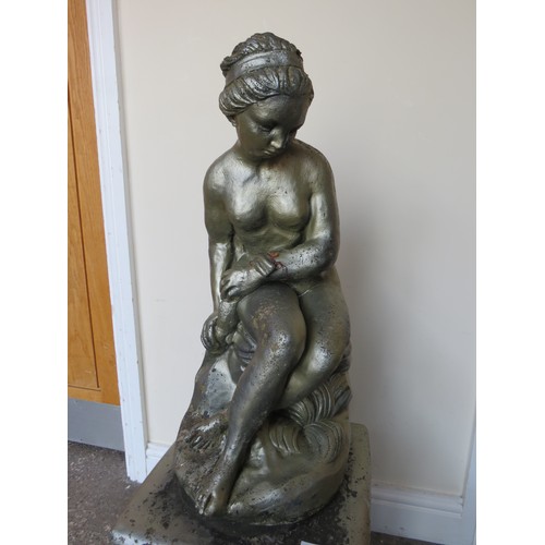 605A - A GARDEN STATUE ON PLINTH OF A FEMALE FIGURE SEATED ON A ROCK, H 94 cm