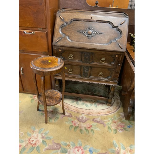 837 - A traditional oak 1930s carved bureau together with a oak plant stand