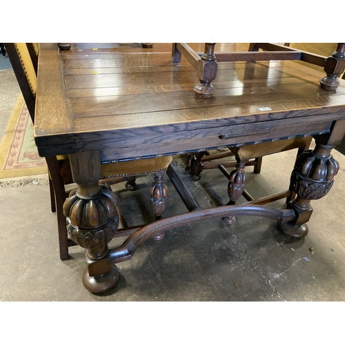 795 - A quality oak heavy draw leaf dining table together with six chairs to include one carver