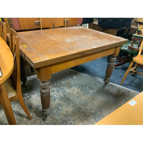 791 - An Edwardian oak draw leaf dining table with fluted supports