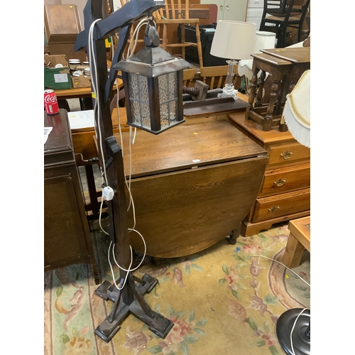 839 - A oak drop leaf dining table together with a lantern style standard lamp