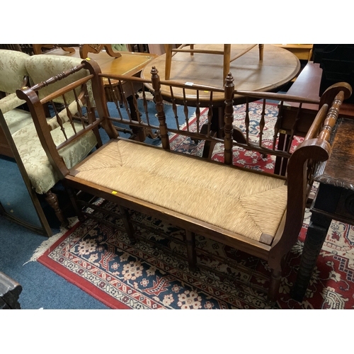 863 - An antique oak spindle back wicker seated bench seat W 133 cm